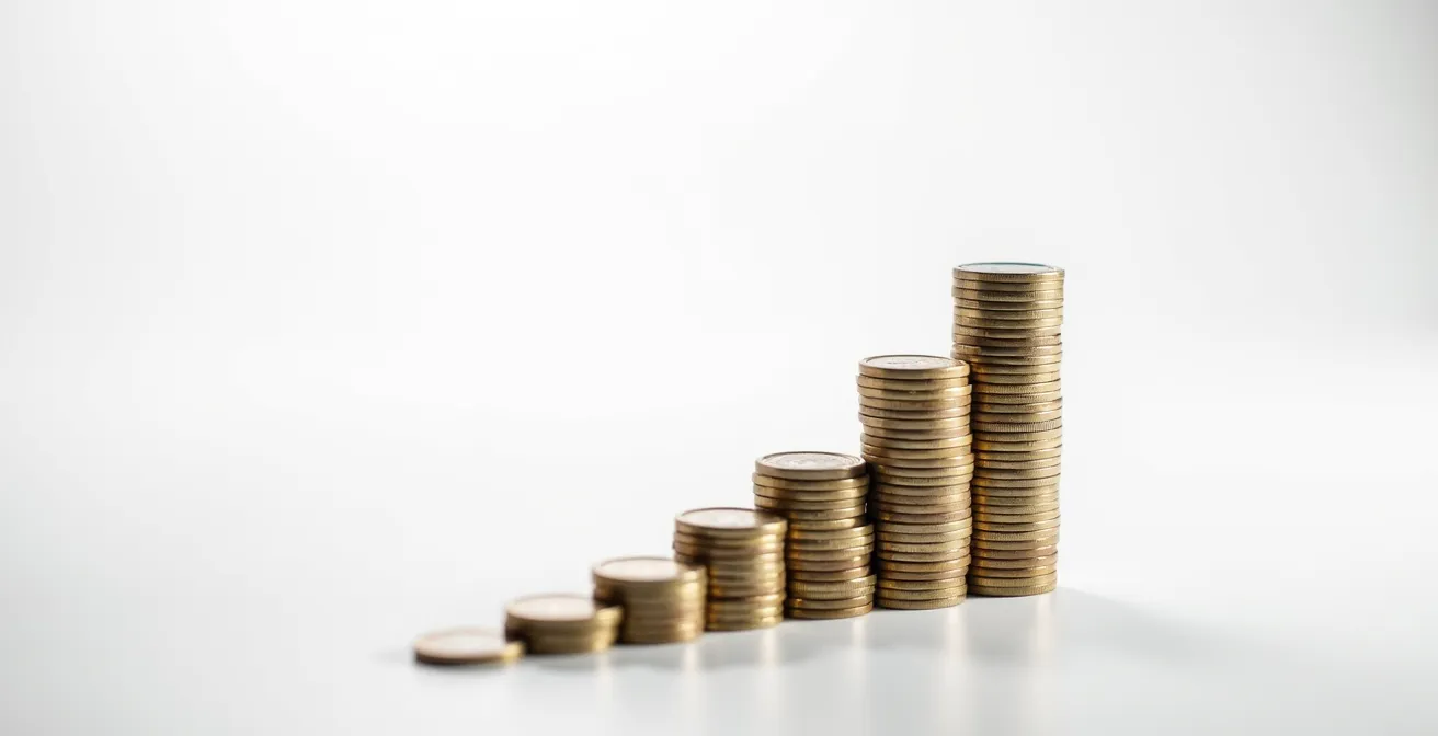 Composition minimaliste de pièces d'euros empilées sur une surface claire avec ombre douce